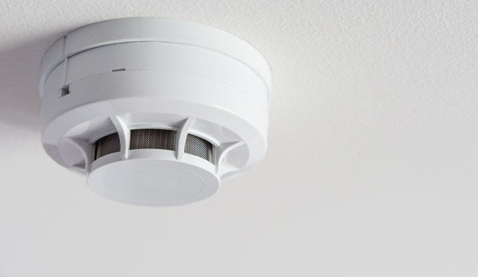 White smoke detector mounted on a ceiling