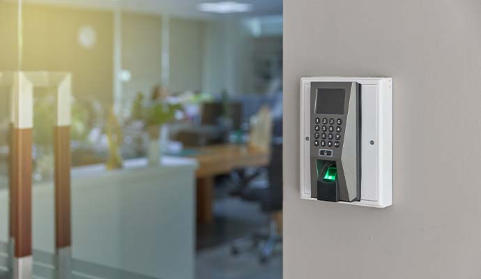 Biometric fingerprint scanner and keypad reader installed next to office door
