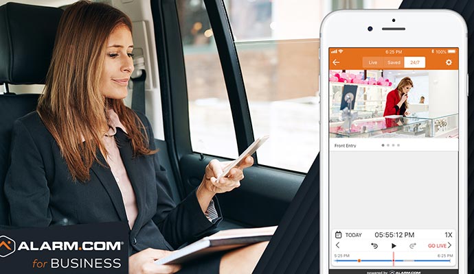 A woman monitoring security camera feeds on a smartphone.