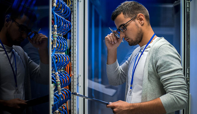 Data center technician checking cables