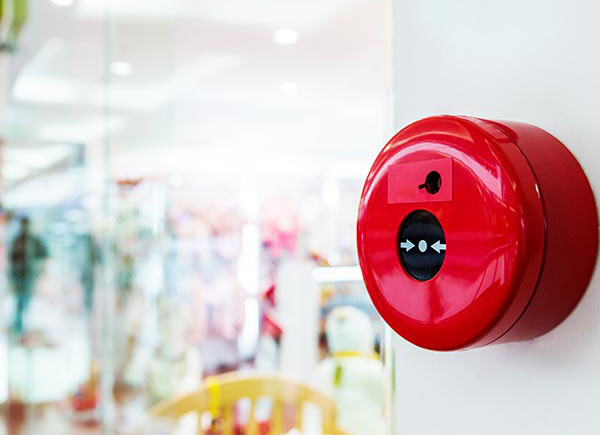A fire alarm is mounted on a wall in a commercial building