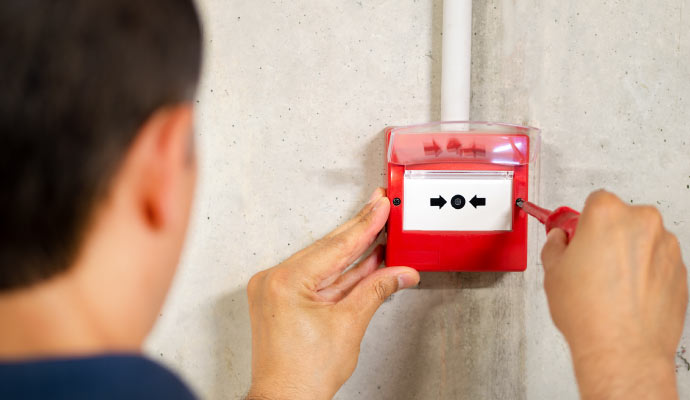 Professional worker installing addressable fire alarm system