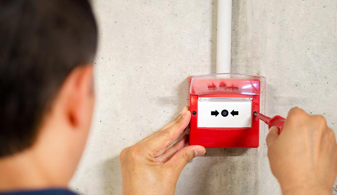 Professional worker installing fire alarm system
