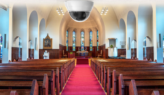 Security camera installed inside a church sanctuary overlooking pews and altar