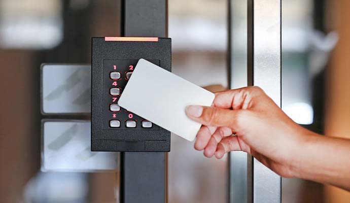 Hand swiping keycard against commercial access control door reader