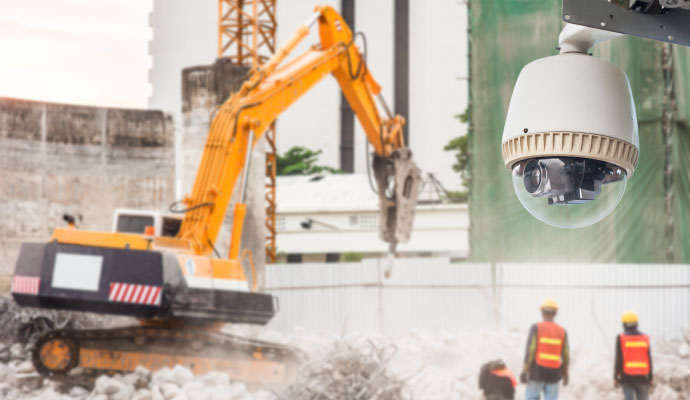 Security camera monitoring a construction site with heavy equipment and workers