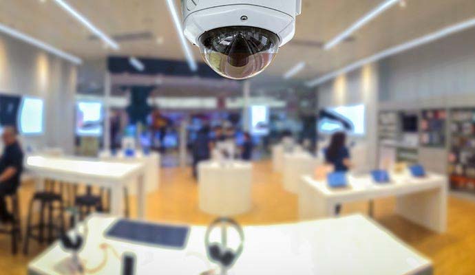Dome security camera installed on ceiling overlooking a retail store interior