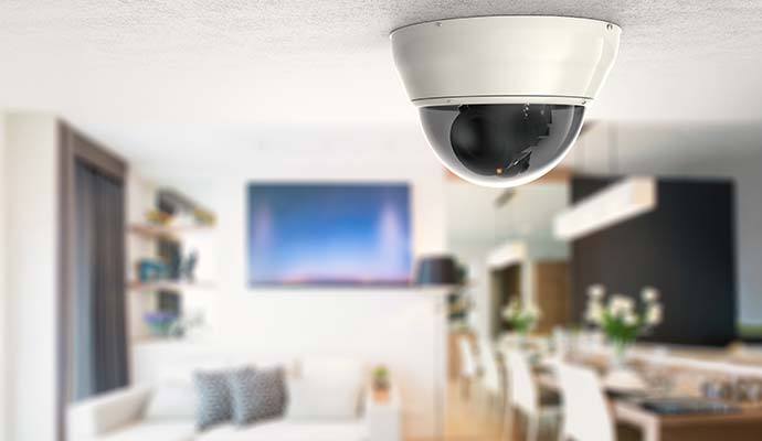 Dome security camera installed on ceiling in living room interior