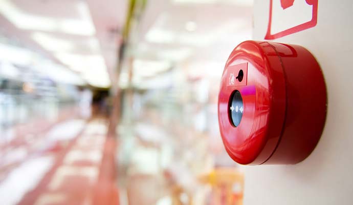 Fire alarm call button mounted on wall in hallway
