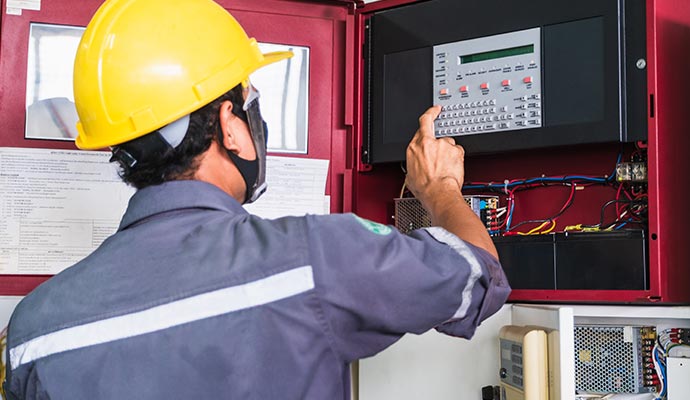 Person inspecting fire alarm