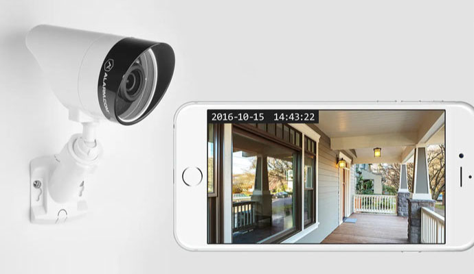 Home security camera with smartphone displaying live video monitoring feed