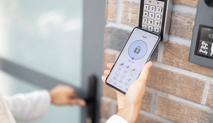 Person unlocking smart door lock keypad entry with smartphone app