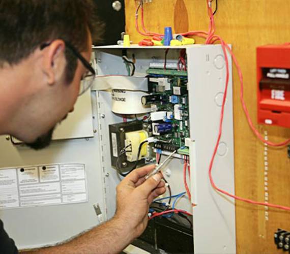 Professional worker installing fire alarm system