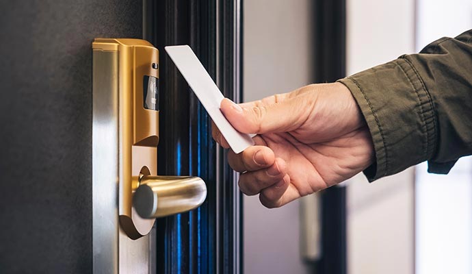 Person using keycard for secure touchless door access and controlled building entry system