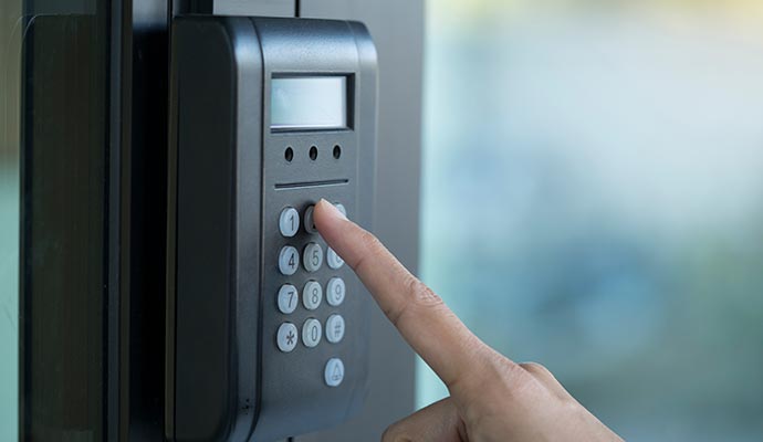 Person pressing a button on a keypad entry system.