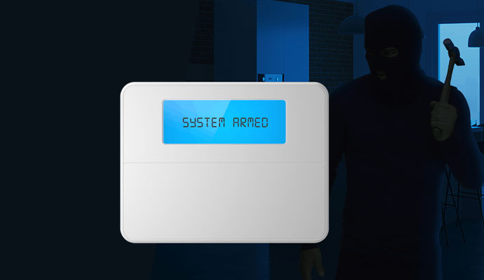 Wall-mounted burglar alarm panel displaying system armed
