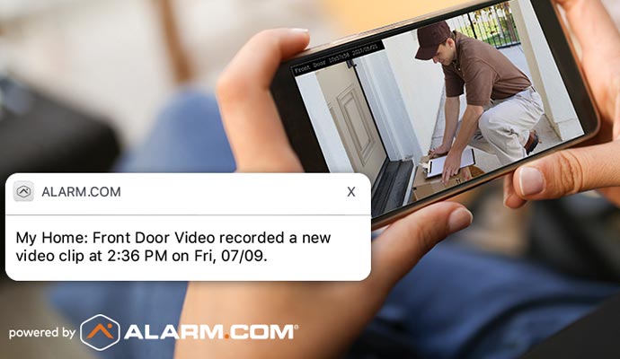 Smartphone displaying front door video monitoring alert and recorded home security camera footage