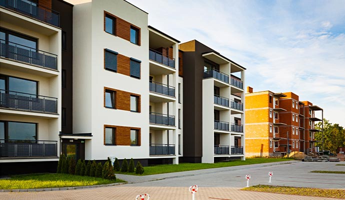 Modern multi family apartment building with balconies landscaped exterior and clean residential property design