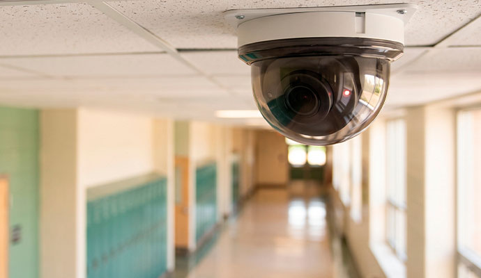 Dome security camera installed in a school hallway