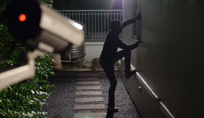 Security camera recording an intruder attempting to enter a property at night
