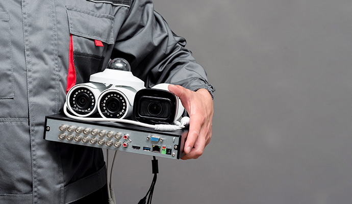 CCTV installation technician holding security cameras