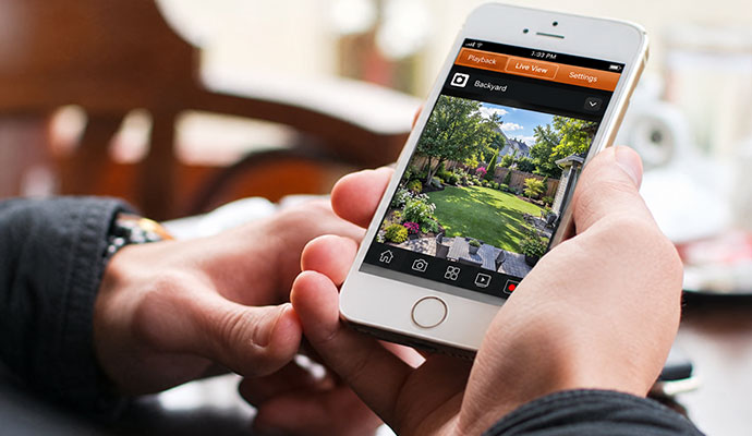Smartphone displaying live backyard security camera feed on mobile app